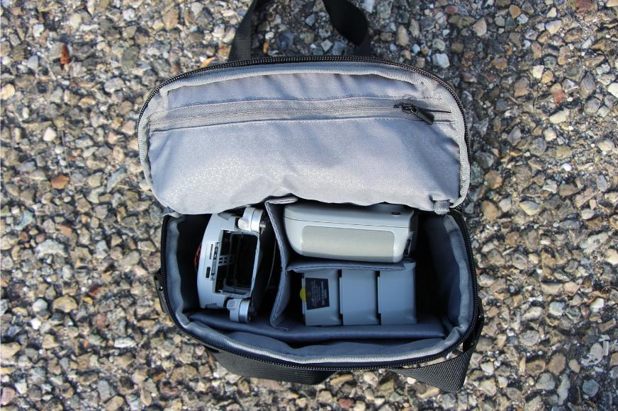 Eine Drohne unter 250g liegt zusammengefaltet in der Reisetasche samt Controller und Zubehör.